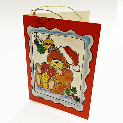 carta Biglietto chiudipacco con filo, Orsacchiotto completo di bustina in carta. Formato cm 4,7x6,8cm. Stampa offset su cartoncino bianco liscio. Cordoncino dorato in dotazione all'interno..