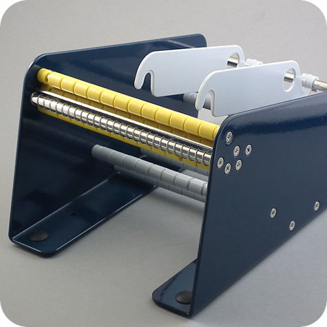 legatoria Dispenser per bollini adesivi, 162 mm Per rotoli di larghezza fino a 162 mm e di diametro fino a 165 mm. 4 piedini antiscivolo. Solida costruzione in metallo. Fornito con 2 supporti per rotoli regolabili.