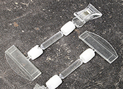 legatoria Doppia molletta Piccola/Portacartellino altezza 130mm TRASPARENTE in policarbonato. Composta da 2 mollette, 1 PICCOLA (38x21mm) e 1 PORTACARTELLINO (50x15mm) collegate da DOPPIO giunto a sfera e gambetto da 38mm. Altezza totale 130mm.