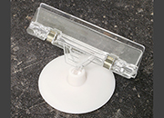 legatoria Porta cartellino con clip 55x80mm TRASPARENTE. Con base cilindrica  AUTOADESIVA di 55mm e clip di ancoraggio snodabile. Altezza 80mm LEG3620