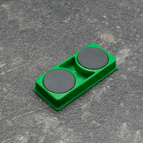 legatoria Calamita rettangolare VERDE, 50x23mm Calamita rettangolare con rivestimento in plastica, VERDE. Spessore 7mm, dotato di due calamite in ferrite poste sulla superficie inferiore. Forza adesiva 1kg..