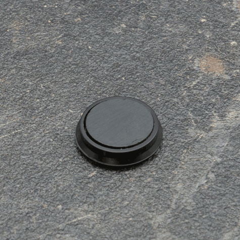 legatoria Calamita tonda NERA, diametro 24mm Calamita rettangolare con rivestimento in plastica, NERO. Spessore 7mm, dotato di due calamite in ferrite poste sulla superficie inferiore. Forza adesiva 300gr..