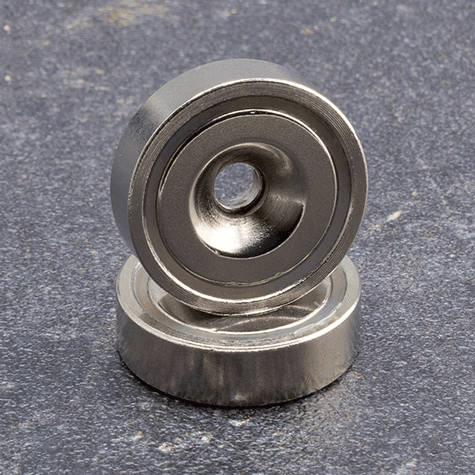 legatoria Magnete con foro svasato, 25mm NICHELATO, in metallo, con magnete al neodimio N38. Diametro: 25mm, altezza: 5mm, larghezza foro: 5.5-11.7mm (forza di attrazione:19kg).