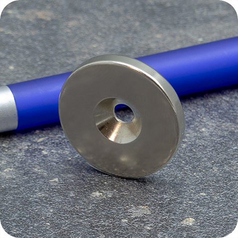 legatoria Magnete con foro svasato, 27mm NICHELATO, in metallo, con magnete al neodimio N35. Diametro: 27mm, altezza: 4mm, larghezza foro: 4.5-9.5mm (forza di attrazione:8000g).