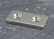legatoria Magnete con fori svasati, 40x20mm NICHELATO, in metallo, con magnete al neodimio N35. Dimensione 40x20mm, altezza: 4mm, larghezza fori: 4.5/9.5mm (forza di attrazione:14kg) LEG4013