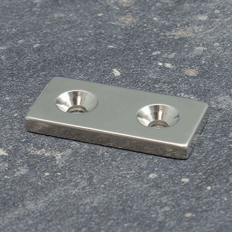 legatoria Magnete con fori svasati, 40x20mm NICHELATO, in metallo, con magnete al neodimio N35. Dimensione 40x20mm, altezza: 4mm, larghezza fori: 4.5-9.5mm (forza di attrazione:14kg).