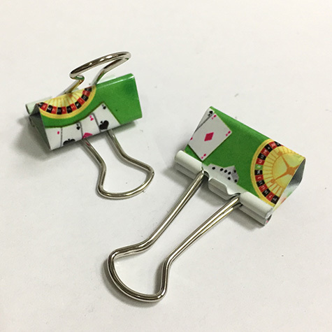 gbc Molle fermacarte double clip, 25mm Casino'    in acciaio, binder clip, con archetti mobili, raccolte in un barattolo di latta con coperchio trasparente la stessa fantasia della mollette, dimensioni barattolo: diamtero 65mm, altezza 75mm. Linea Funny desk by Molho Leone.