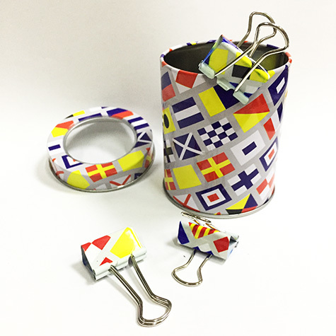 gbc Molle fermacarte doubleclip, 25mm SailingFlags in acciaio, binder clip, con archetti mobili, raccolte in un barattolo di latta con coperchio trasparente la stessa fantasia della mollette, dimensioni barattolo: diamtero 65mm, altezza 75mm. Linea Funny desk by Molho Leone.