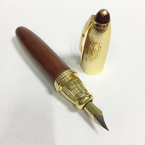 gbc Penna stilografica mini OSAMA LEGNO Pennino Iridium Point Germany originale. Fusto in legno placcata in oro. Da collezione, Dimensioni: 15x95mm. completa di astuccio.